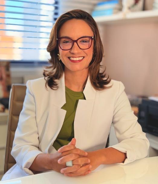 Dra. Jessica Castro sorrindo em seu consultório